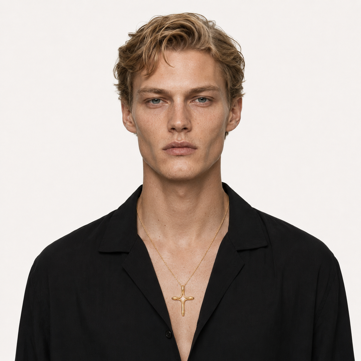 Model in a black shirt wearing a gold cross necklace