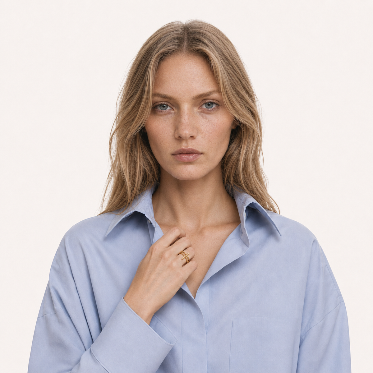 Model in a blue shirt wearing a gold Relic necklace